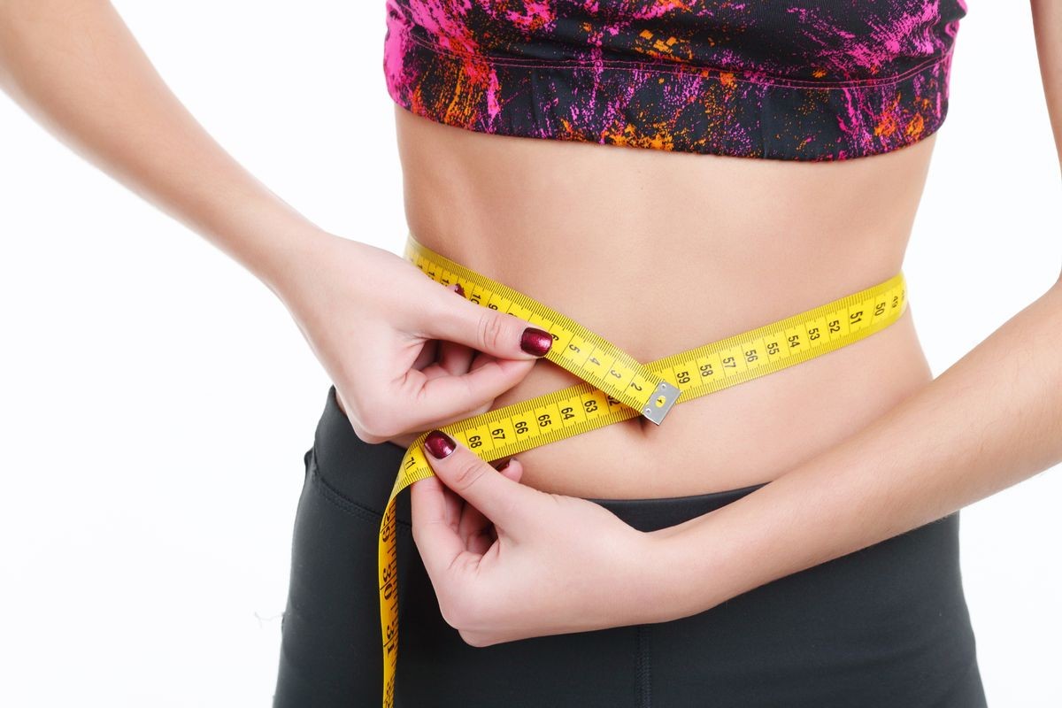 Woman measuring her body - medical weight loss concepts Woman measuring her body - medical weight loss concepts