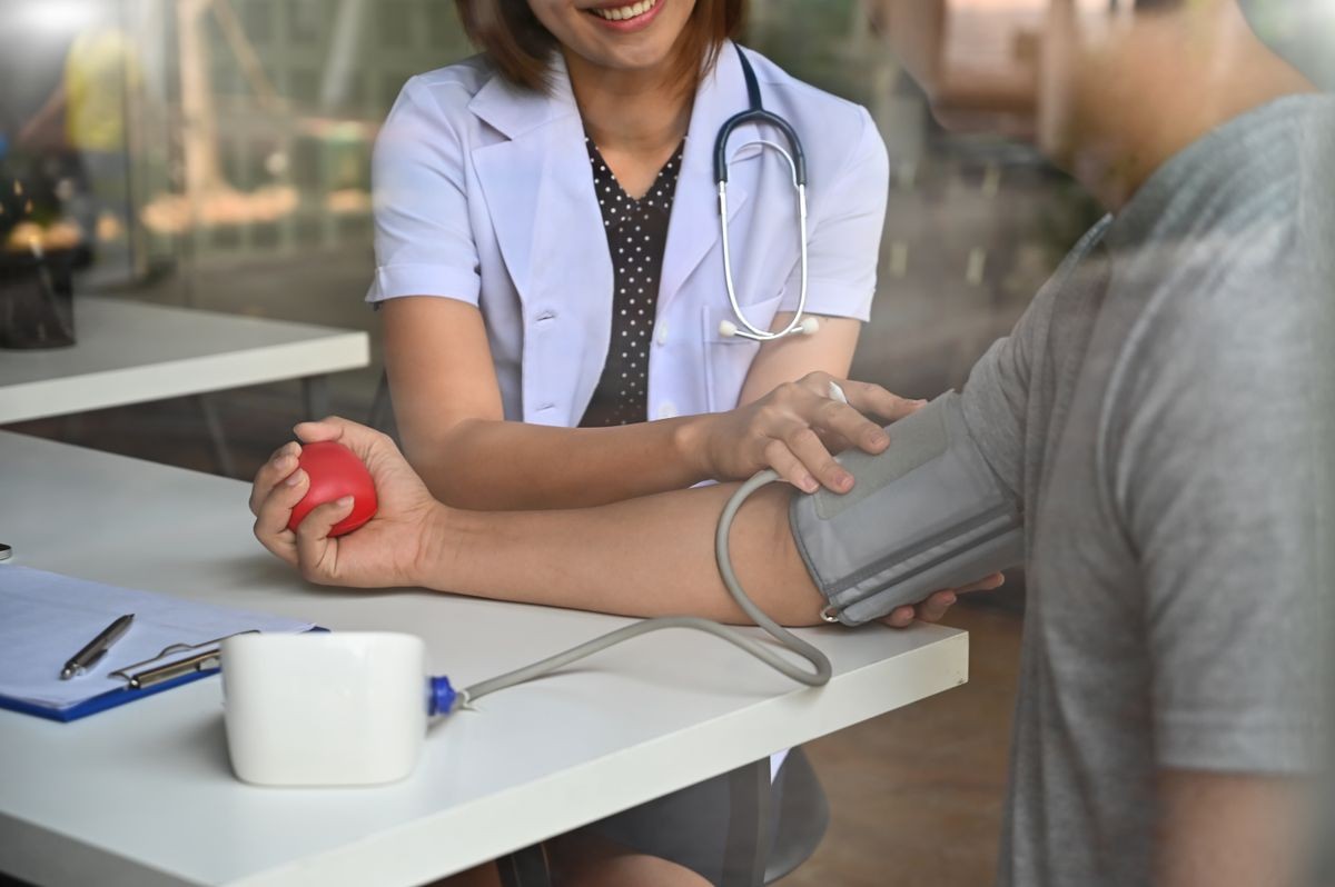 Doctor Checking blood pressure her using sphygmomanometer with stethoscope to a patient. Doctor Checking blood pressure her using sphygmomanometer with stethoscope to a patient.